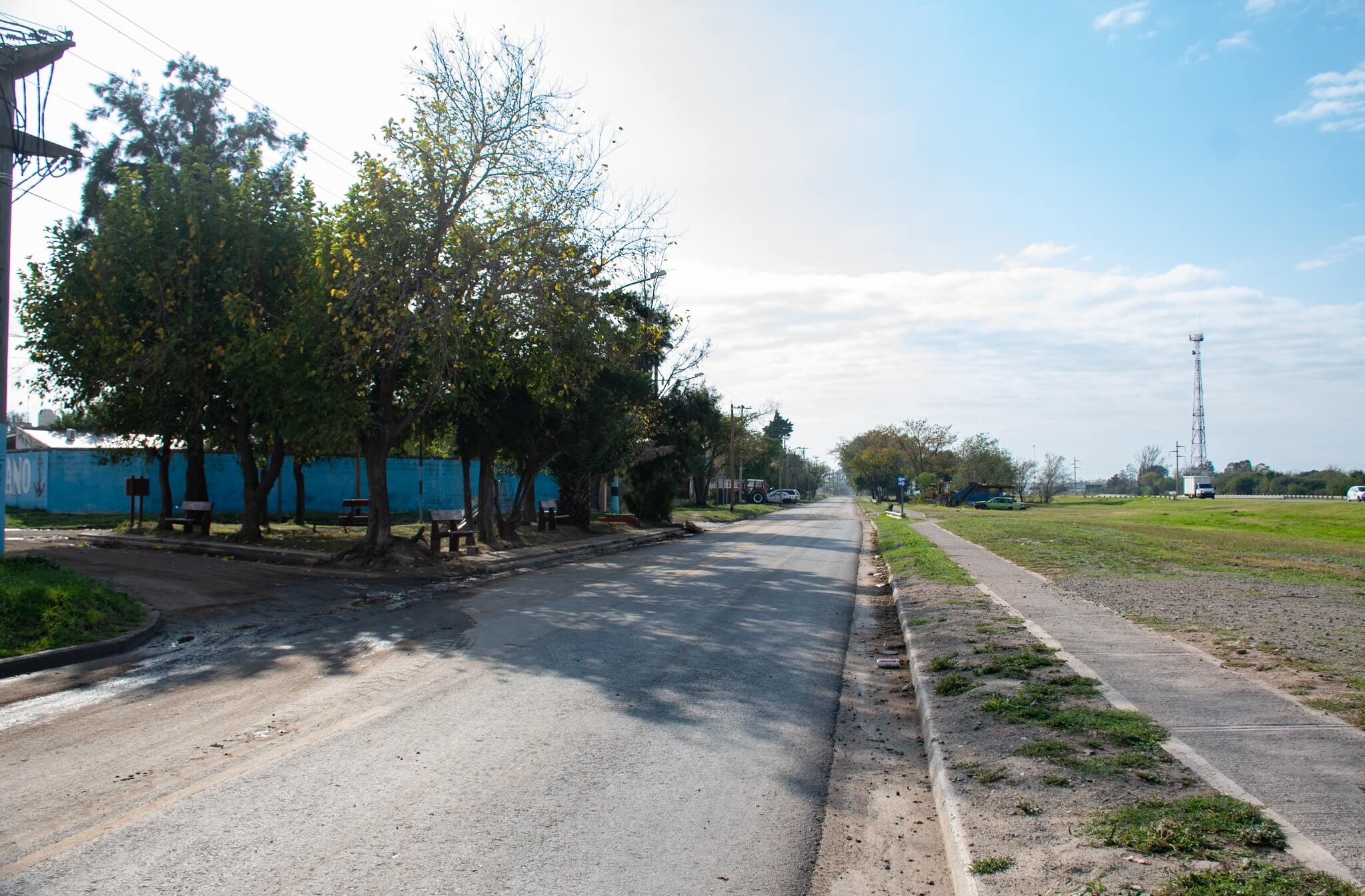 Vista de calle y vereda en Malvinas Argentinas, con arbolado y espacio urbano abierto.