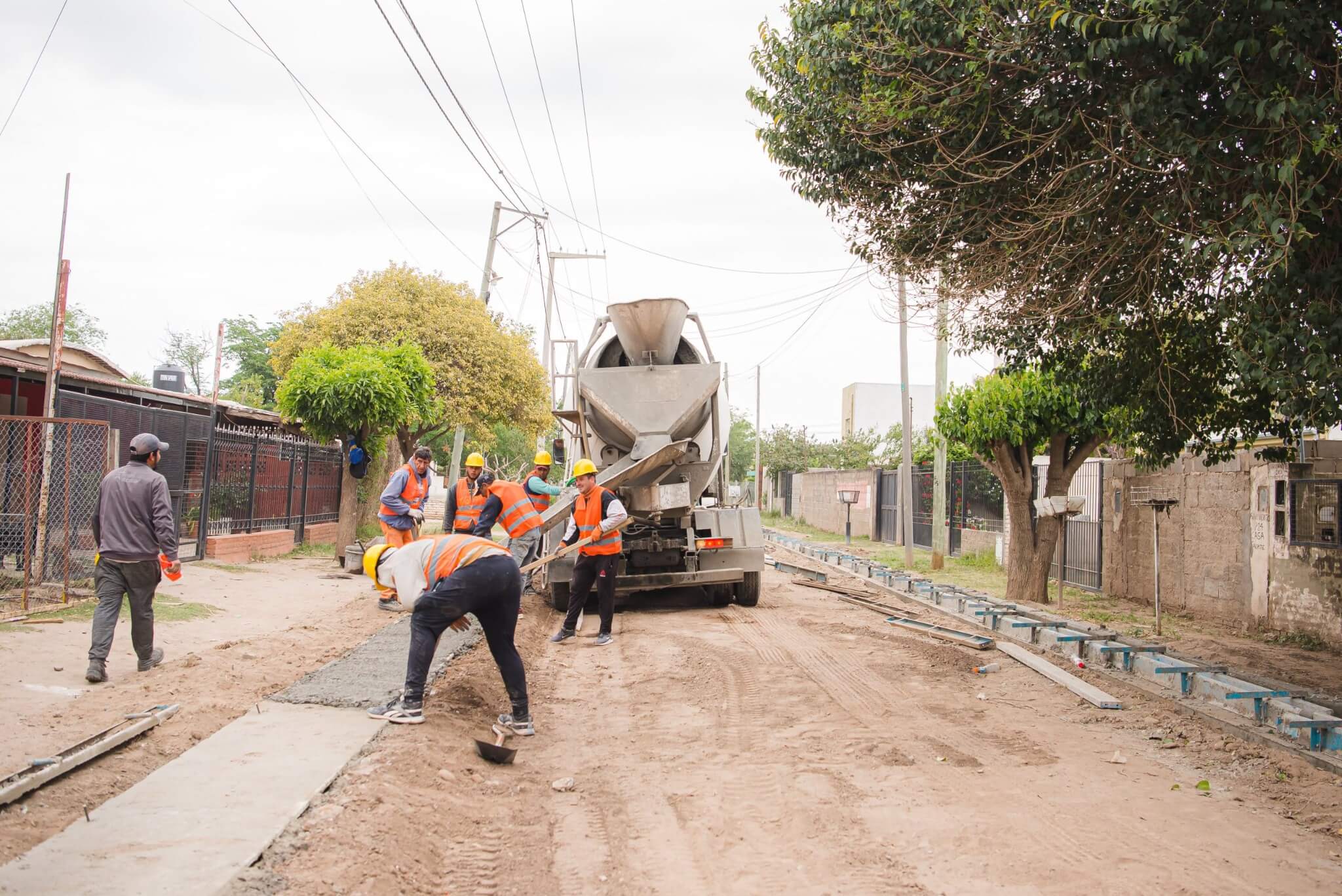 Personal municipal ejecutando una obra de vereda y hormigón en una calle de Malvinas Argentinas.